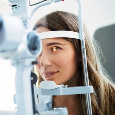 Woman undergoing an ophthalmic consultation using a slit lamp examination to assess dry eyes, blepharitis, and ocular health at Lisa Franklin dry eye clinic.